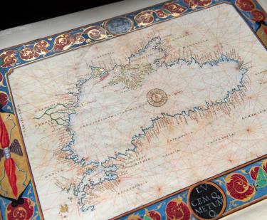 Detail of a colored manuscript map shows the Black Sea with labels. Decorative border includes red, blue, and green ink and gilded details.