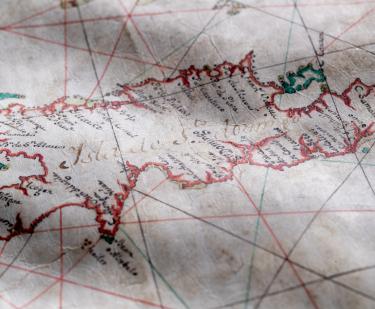 Detail of a colored manuscript map shows text in Spanish over Hispaniola reading "Isla de Sto. Domingo" with other smaller labels.