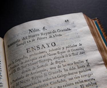 Detail from a printed book shows text in Spanish including "Ensayo" at the top of the page.