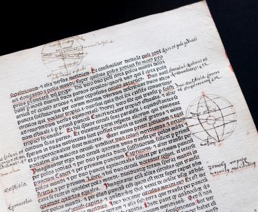Detail from a printed book shows red and black text in Latin, geometrical sketches in the margins, and manuscript notations in the margins and underlining.