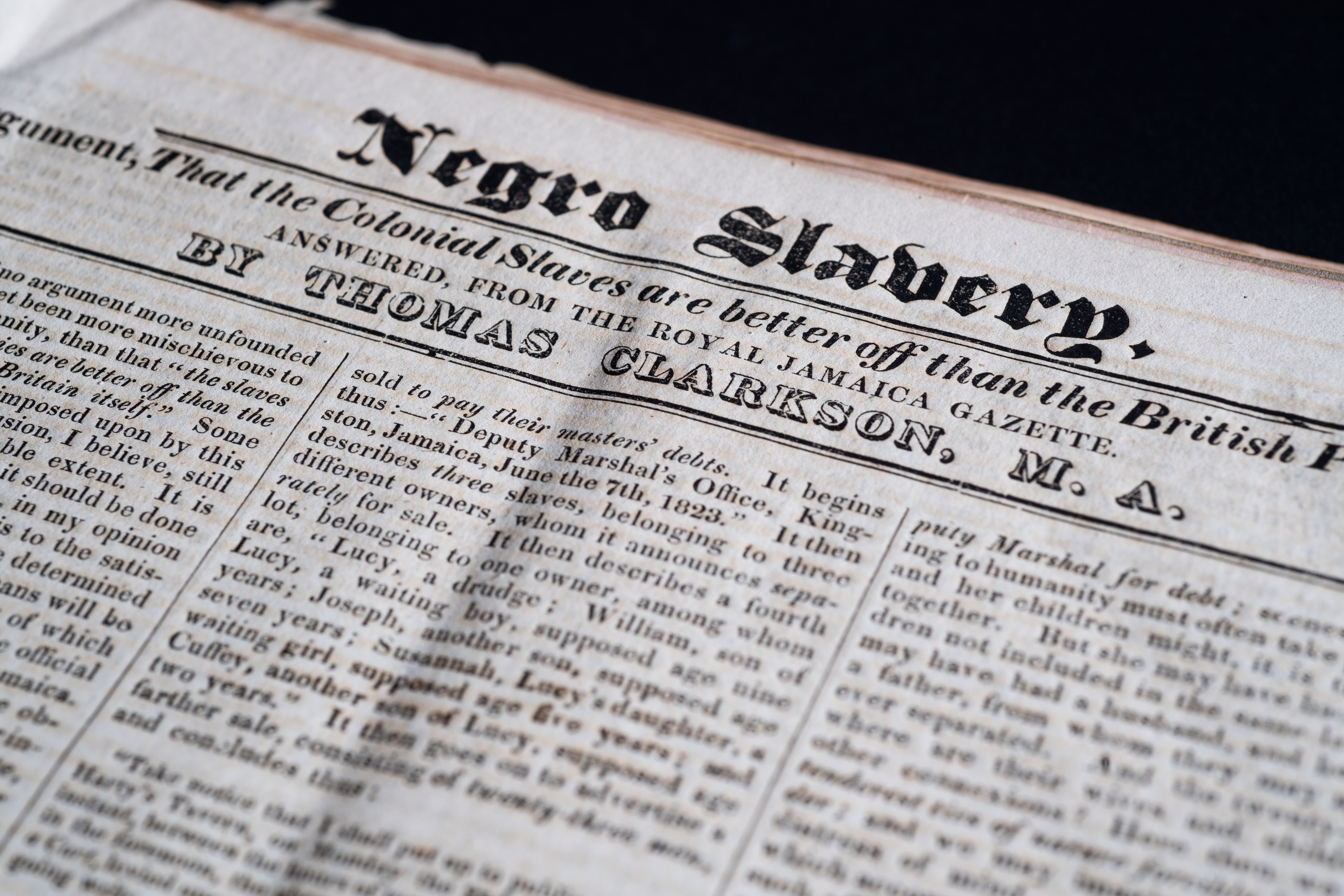 Detail of a printed newspaper shows headline "Negro Slavery" and other text in English.