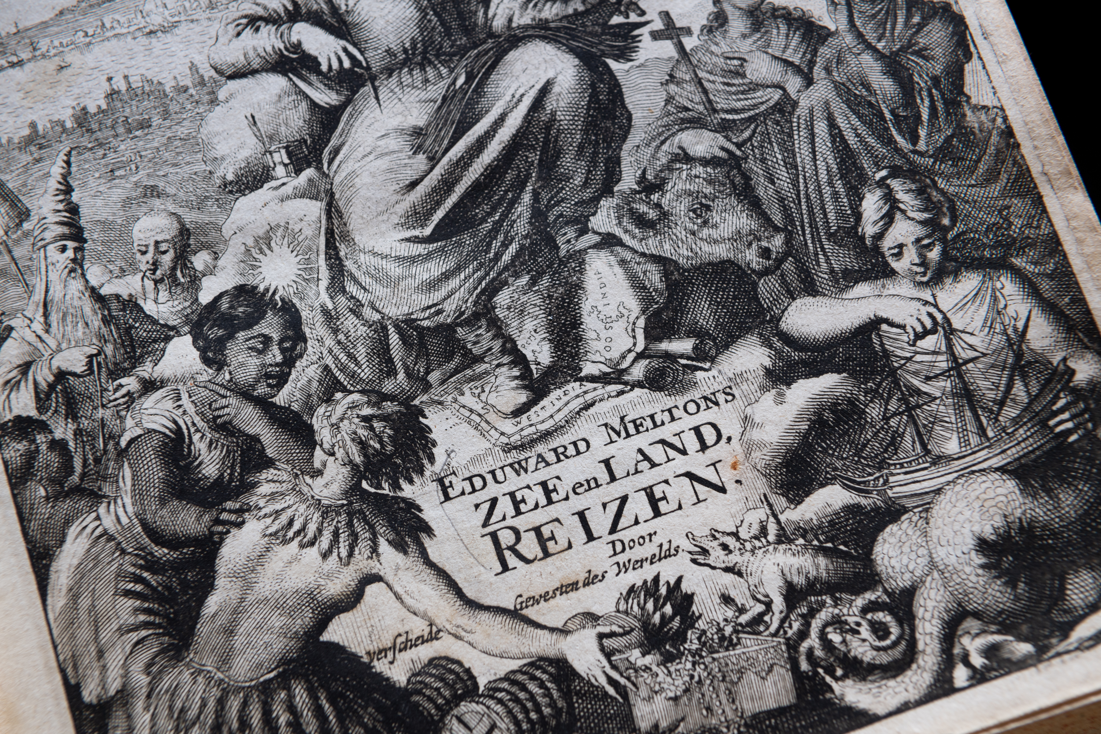 Detail of a printed book shows engraved title page depicting women, ships, and animals. Text in Dutch.