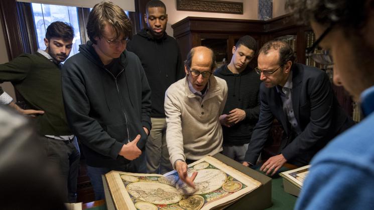 group of people standing around a map on a table