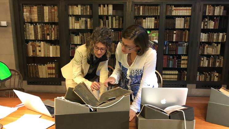 Lisa Voigt, spanish/portuguese at Ohio state university, and Stephanie leitch, art history at Florida state university, standing over a table at the JCB’s