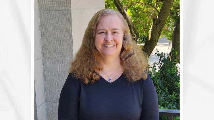 The photograph shows Judy Dowling, Library Specialist-Metadata, standing on the front steps of the Library.