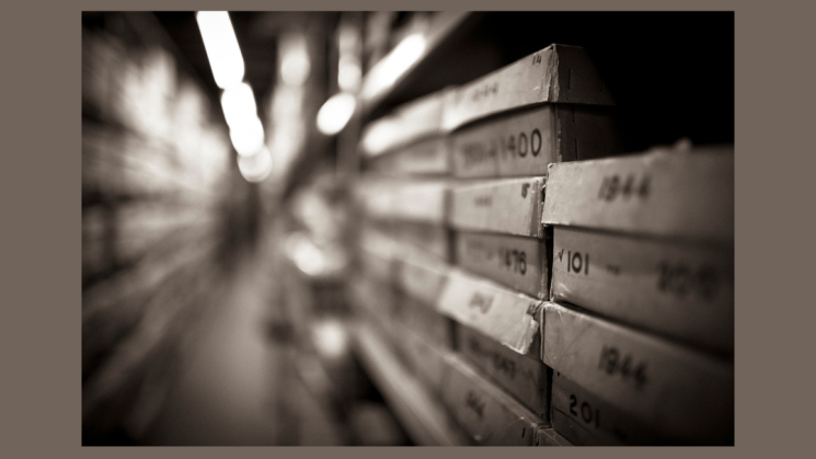 The image shows a row of boxes in an archive.