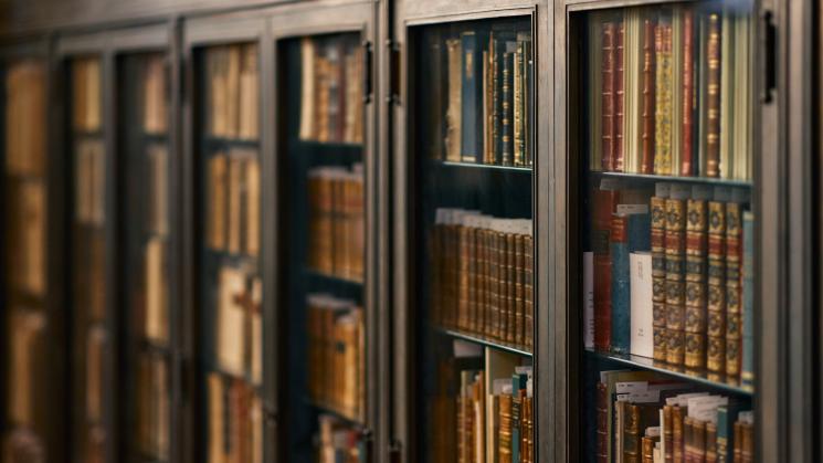 The image shows shelves of books in the JCB Reading Room.