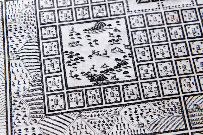 Detail of an engraved map of Azilia shows deer and trees in one of the four quadrants in Azilia. Farmland at the border of the city is visible.