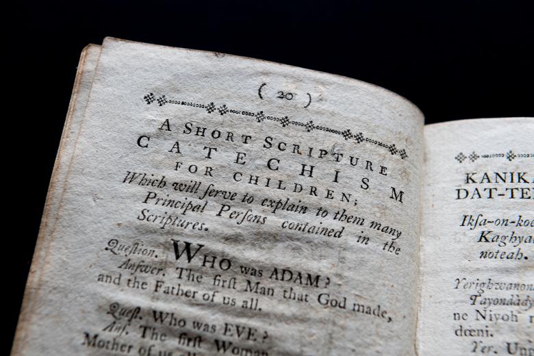Detail of a printed book shows text in English reading "A short scripture catechism for children" at the top of the page.
