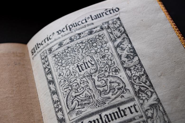 Detail of Mundus Novus' title page which depicts two monkeys sitting by a tree, framed by plants and text in Latin.