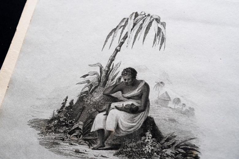 Detail of a printed document shows a sketch of a woman holding a baby as she's seated by a palm tree.