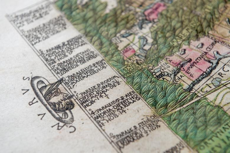 Detail of a hand colored map, engraved in copper, shows Latin text in the margins and a wind head.
