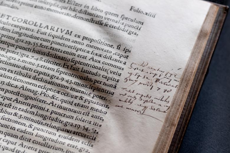 Detail of a printed books shows text in Latin and manuscript annotations in the border.