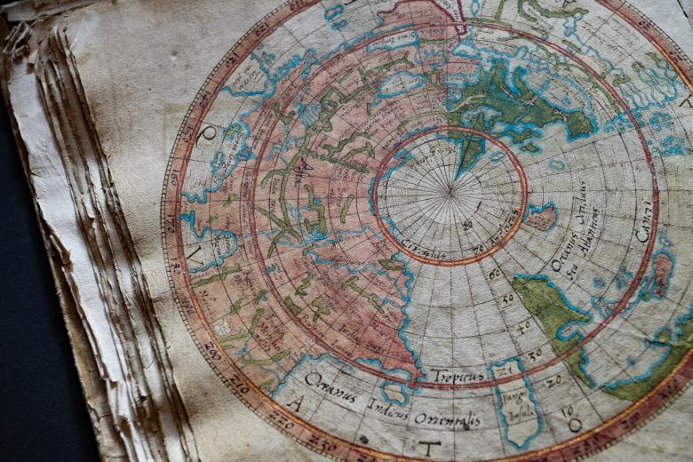 Detail from a colored manuscript map shows the world labeled with text in Latin.