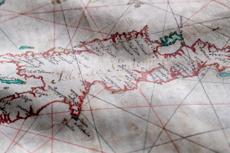 Detail of a colored manuscript map shows text in Spanish over Hispaniola reading "Isla de Sto. Domingo" with other smaller labels.