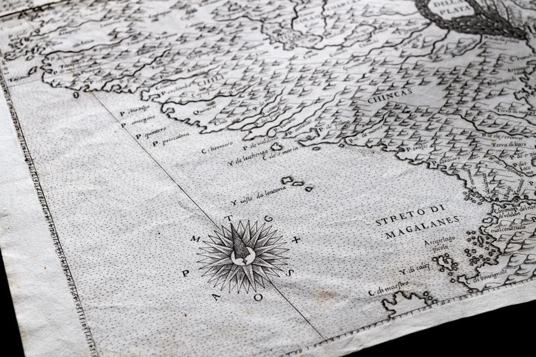 Detail of an engraved map shows mountainous topography and text in Italian reading "Streto di Magalanes" over the Magellan Strait. Compass rose and other labels are visible.