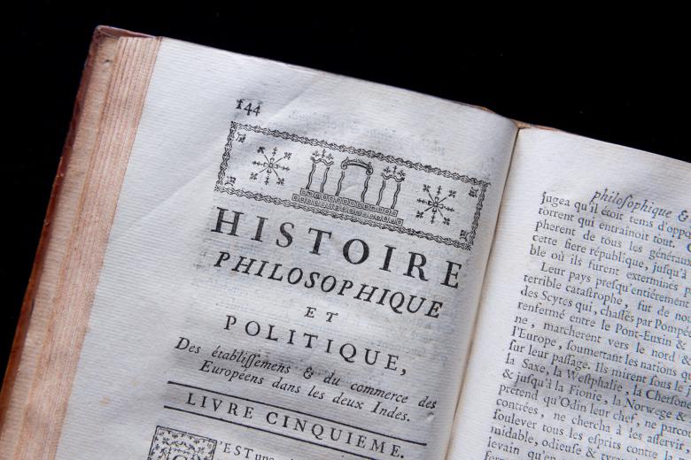 Detail of a printed book shows a decorative headpiece and text in French reading on a title page reading "Livre Cinquieme."