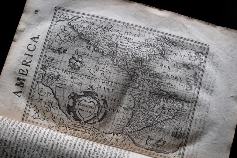 A full-page map includes a decorative cartouche, latitude and longitude lines, ships and sea monsters. Text within the map is in Latin and the map is titled "America."