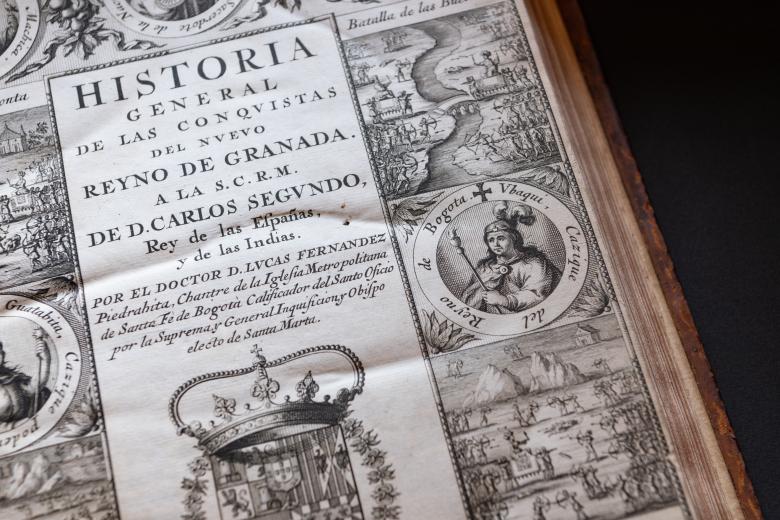 Detail of an engraved title page shows medallion portraits at the border, a coat of arms, and text in Spanish. Illustrations of the landscape are also drawn in the borders.