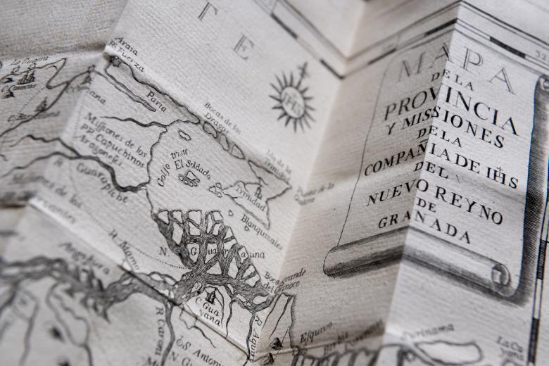 Detail of a printed fold-out map shows text and labels in Spanish and topographical information.