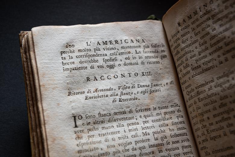 Detail of a printed book shows text in Italian.