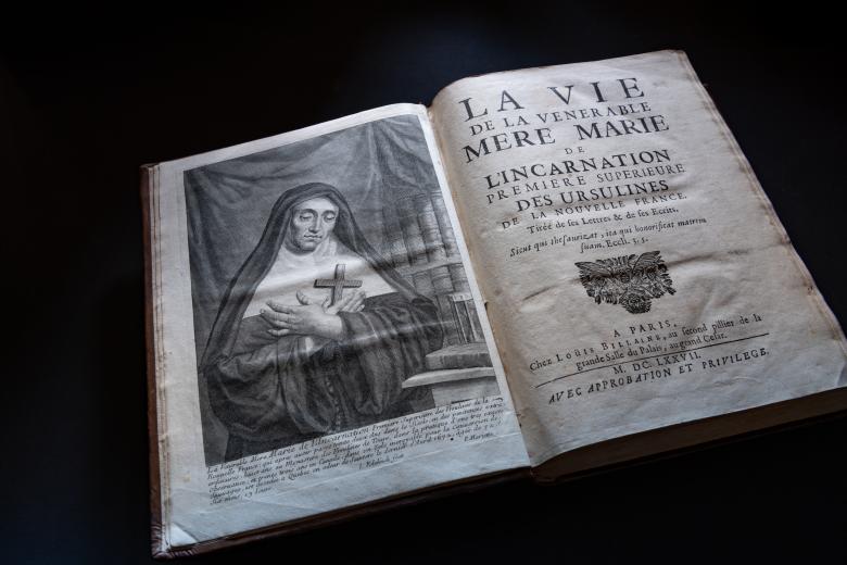 Detail of a printed book shows a frontispiece of a nun holding a cross. The title page is written in French and includes a decorative flourish.