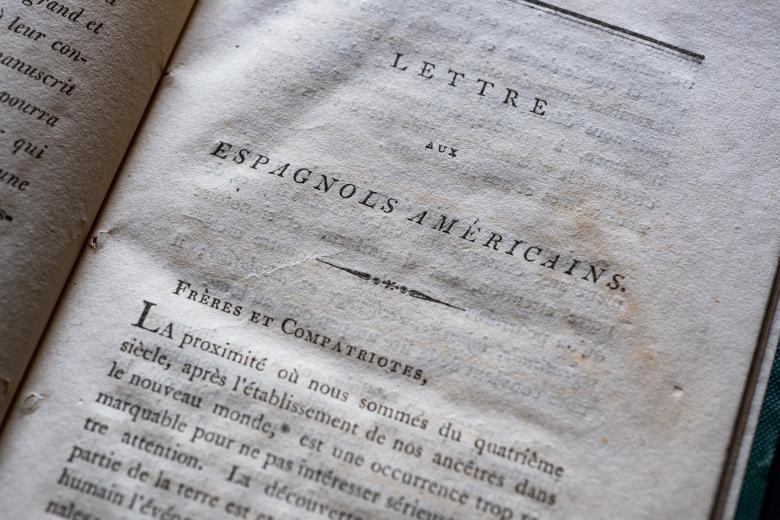 Detail of a printed book shows text in French on the title page reading "Letter aux espagnols américains."