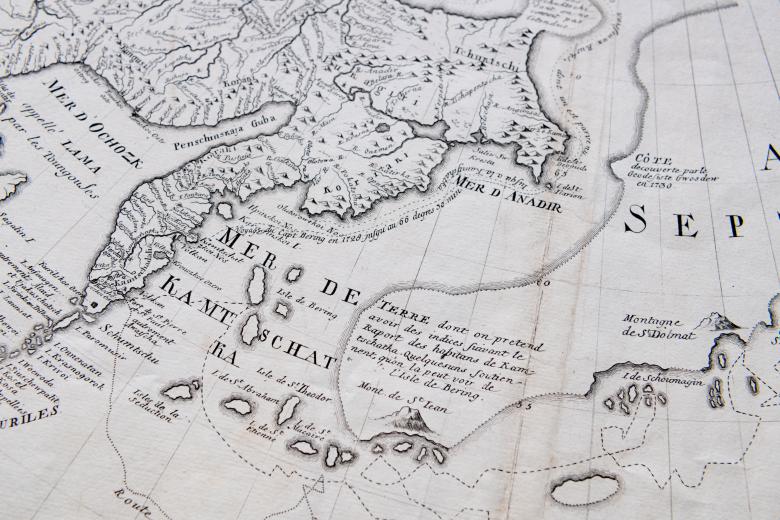 Detail of a printed map shows latitude and longitude lines and text in French such as "Mer de Kamtschatka."