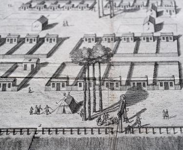 Detail of an engraved map shows people standing around a tent that is surrounded by a grid layout.