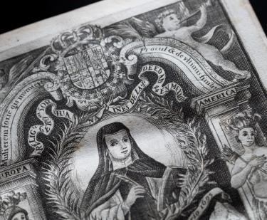 Detail of a printed book shows a decorated title page depicting an illustration of Sor Juana, angels, indigenous people, and text in Spanish and Latin.