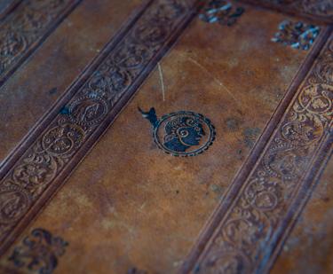 Detail of brown book binding shows the embossed details.
