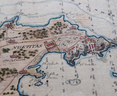 Detail of a hand-colored manuscript map shows small depth markers, forest, and a label "Nuevitas" and other surrounding landmarks.