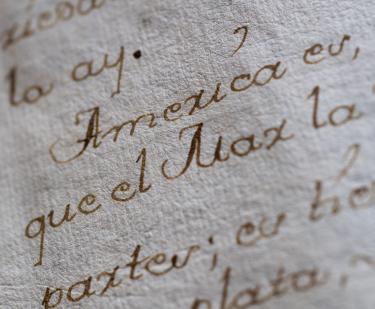 Detail from a manuscript codex shows "America" in focus within a Spanish text.