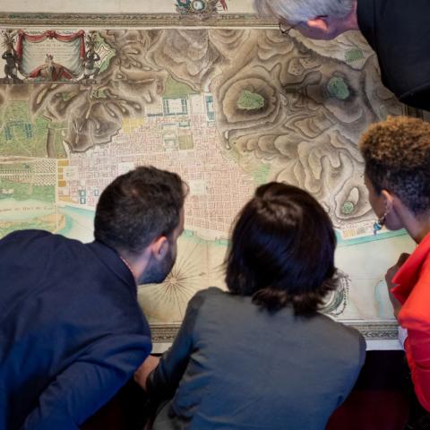 Four researchers examine a map