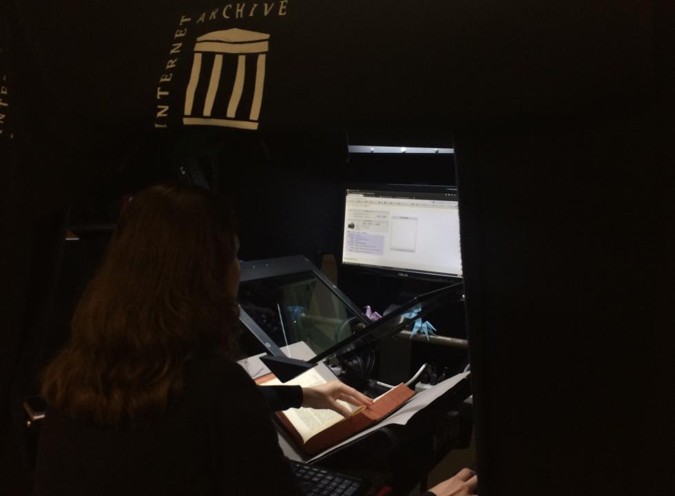 A member of the JCB staff works in a book scanner