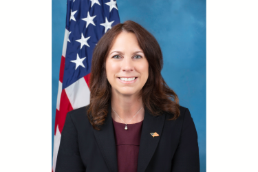 The image shows a formal photograph of Colleen Shogan.